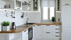 A remodeled kitchen with white cabinets.