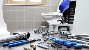 Plumber tools and equipment in front of a toilet