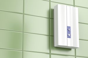 Modern, tnakless water heater installed on a light green tile wall